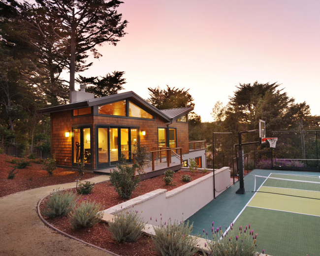 Загородный дом с баскетбольной площадкой, расположенный на склоне