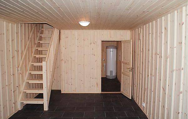 На фото деревянная одномаршевая лестница в комфортное подвальное помещение дома.